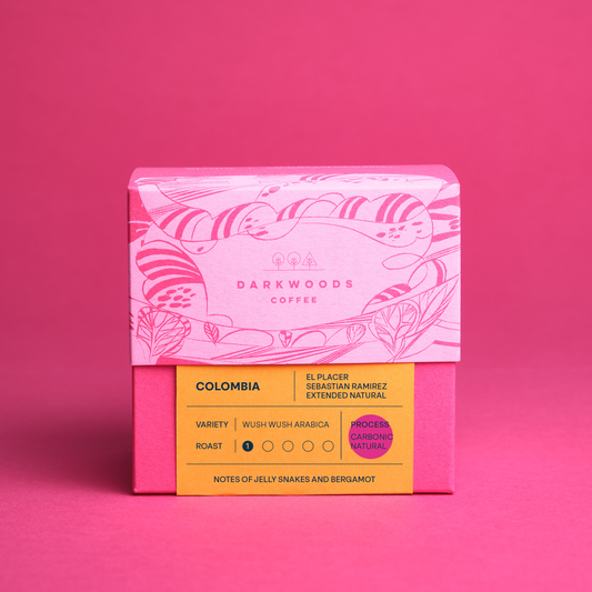 Pink coffee packaging with 'Darkwoods Coffee' on a pink background